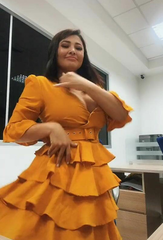 3. Beautiful Milagro Flores Shows Cleavage in Sexy Orange Dress