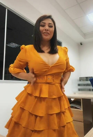 4. Beautiful Milagro Flores Shows Cleavage in Sexy Orange Dress