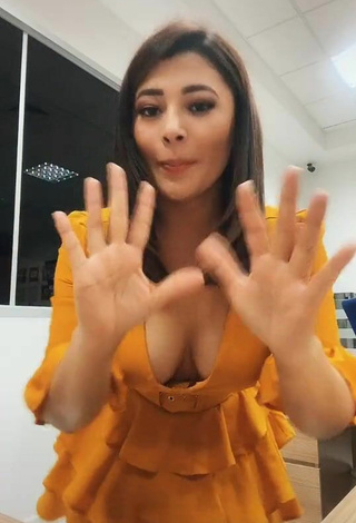 5. Beautiful Milagro Flores Shows Cleavage in Sexy Orange Dress