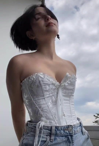 Cute Angelique Shows Cleavage in White Corset on the Balcony