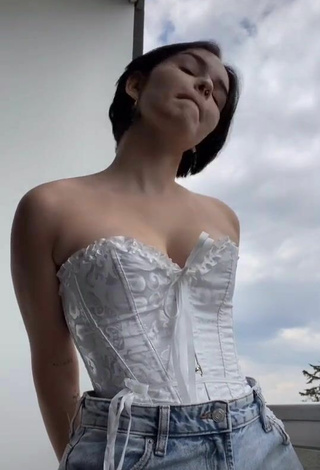 2. Cute Angelique Shows Cleavage in White Corset on the Balcony