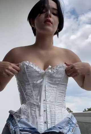 4. Sexy Angelique Shows Cleavage in White Corset on the Balcony