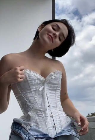 6. Sexy Angelique Shows Cleavage in White Corset on the Balcony