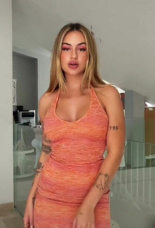 2. Hot Abril Cols Shows Cleavage in Orange Dress